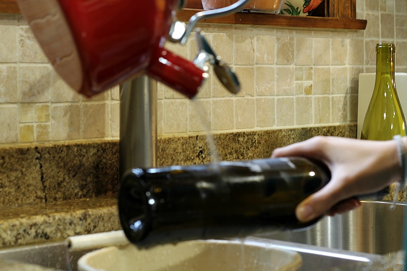 verter agua hirviendo en una botella de vino marcada